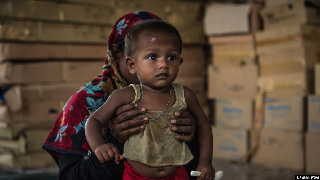 Seorang ibu pengungsi Rohingya menggendong anaknya yang dirawat karena kekurangan gizi di klinik LSM Aksi Melawan Kelaparan di Ukhiya, Bangladesh, 18 April 2018. 