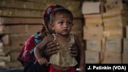 Seorang ibu pengungsi Rohingya menggendong anaknya yang dirawat karena kekurangan gizi di klinik LSM Aksi Melawan Kelaparan di Ukhiya, Bangladesh, 18 April 2018. 