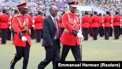 Le président élu de la Tanzanie, John Magufuli, est escorté après avoir inspecté une garde d'honneur militaire tanzanienne lors de sa cérémonie d'investiture au stade Uhuru à Dar es Salaam, le 5 novembre 2015.