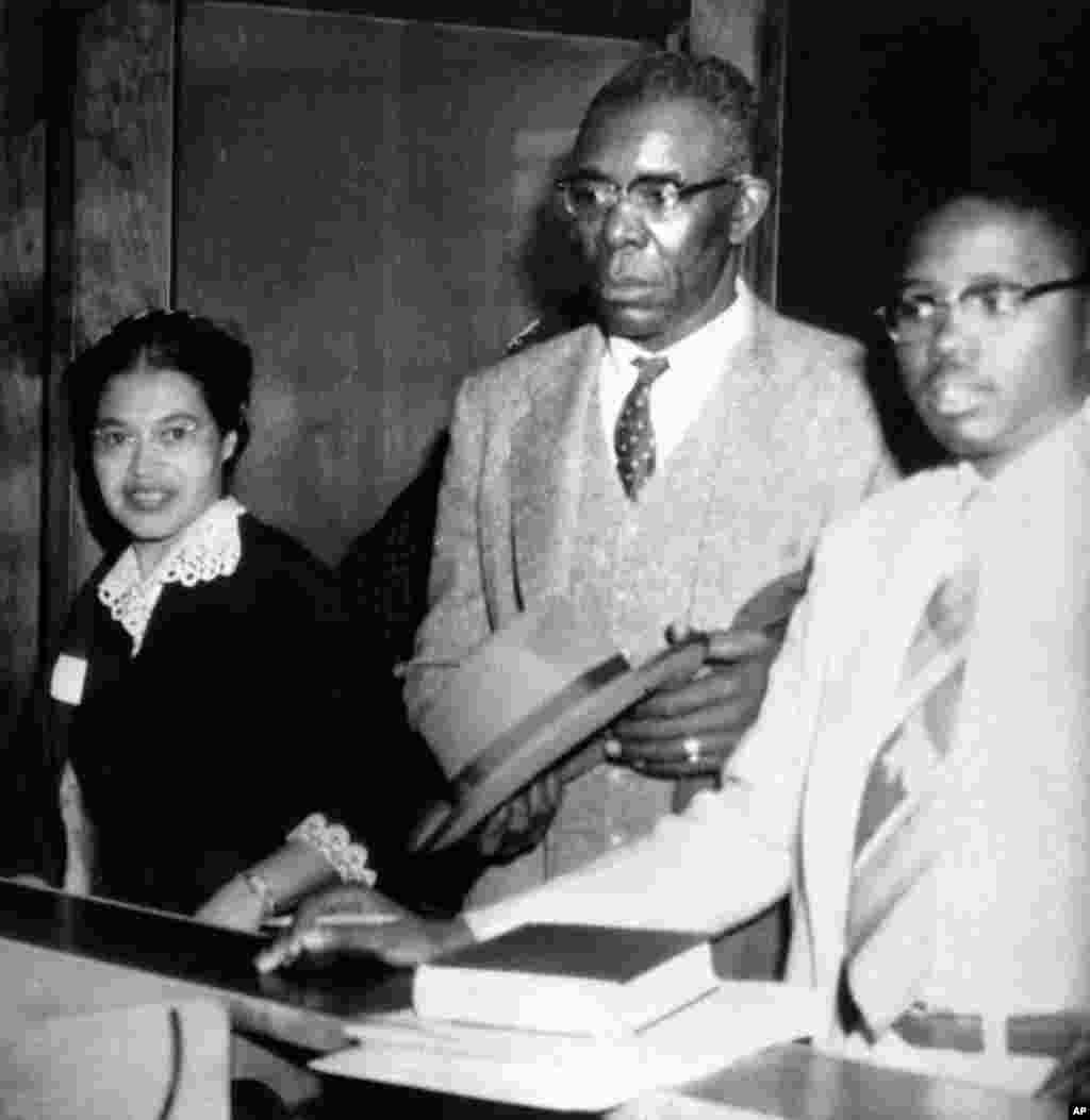 FILE - Rosa Parks, left, who was fined $10 and court costs for violating Montgomery's segregation ordinance for city buses, makes bond for appeal to Circuit Court, Dec. 5, 1955. 