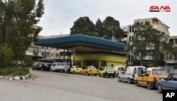 This file photo released on April 7, 2019, by the Syrian official news agency SANA, shows cars queuing to fill their tanks with fuel, at a gas station in Daraa, south Syria.