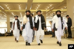 FILE - Afghanistan's Taliban delegation arrive for the agreement signing between Taliban and U.S. officials in Doha, Qatar, Feb. 29, 2020.