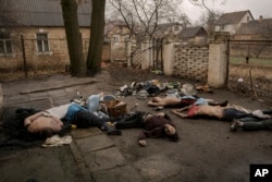 FILE - The bodies of men, some with their hands tied behind their backs, lie on the ground in Bucha, Ukraine, April 3, 2022. Executions are among the human rights violations the U.N. says Russia has committed.