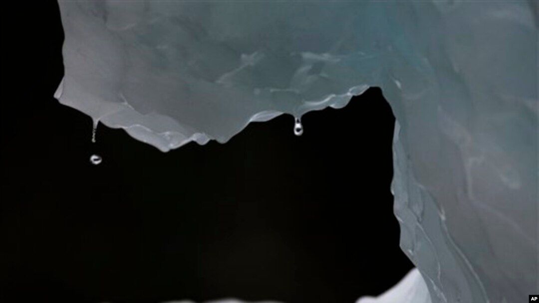 In this July 26, 2011 photo, drops of water fall from a melting iceberg near Nuuk, Greenland. Greenland is the focus of many researchers trying to determine how much its melting ice may raise sea levels. (AP Photo/Brennan Linsley)
