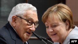 FILE - German Chancellor Angela Merkel joins former US Secretary of State Henry Kissinger at a conference titled "70 Years of Marshall Plan" organised by the German Marshall Funds of the United States at the Deutsches Historisches Museum in Berlin on June 21, 2017.