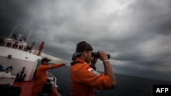 FILE - Indonesian national rescue personnel conduct search for missing Malaysia Airlines flight MH370, Andaman Sea, March 15, 2014.