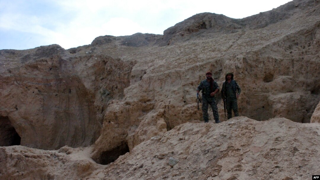 Two fighters from the Syrian Democratic Forces, the Kurdish-Arab alliance backed by the US fighting the Islamic State (IS) group, stand at the Tal Ajaja archeological site in Syria's northeastern Hassakeh province, Aug. 3, 2016.