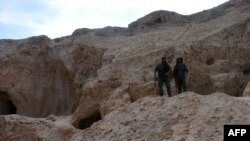 Combatientes de las Fuerzas Democráticas Sirias, la alianza kurda-árabe que apoya Estados Unidos en la lucha contra el Estado Islámico resguardan un sitio arqueológico en Hasaka, noreste de Siria.