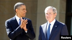 FILE - U.S. President Barack Obama applauds as former president George W. Bush arrives on stage at the dedication ceremony for the George W. Bush Presidential Center in Dallas, April 25, 2013.