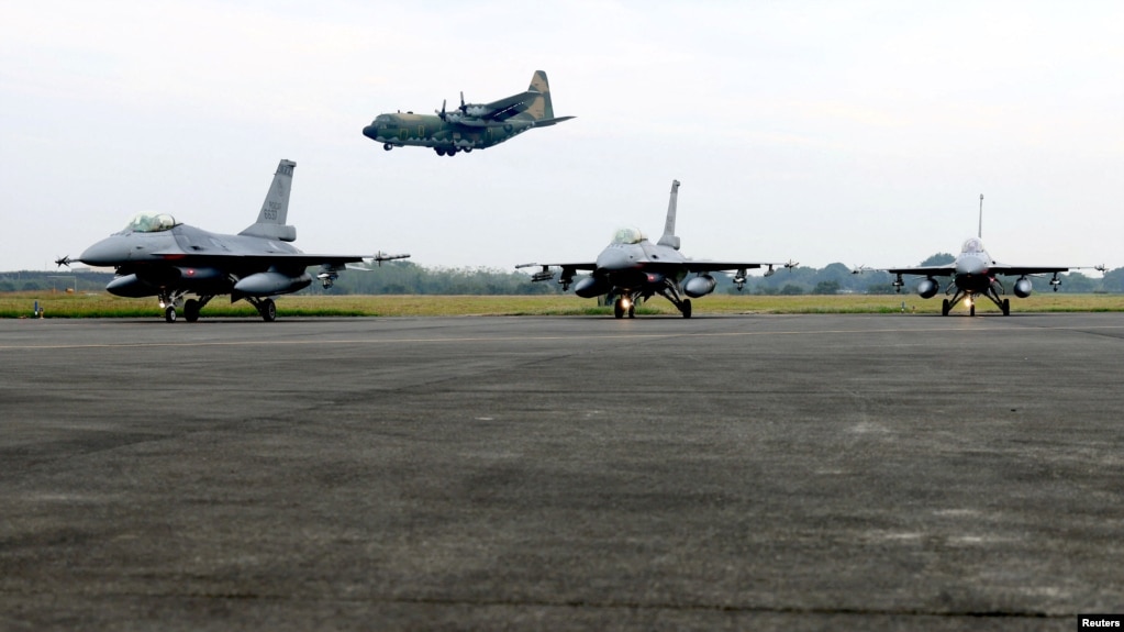  A Taiwan C-130 flies past two F-16V fighter planes during training in Chiayi, Taiwan, January 5, 2022. REUTERS/Ann Wang