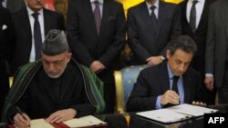 Tổng thống Pháp Nicolas Sarkozy (phải) và Tổng thống Afghanistan Hamid Karzai ký hiệp định hợp tác và hữu nghị tại Điện Élysée ở Paris hôm 27/1/12