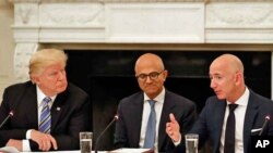 President Donald Trump, left, and Satya Nadella, Chief Executive Officer of Microsoft, center, listen as Jeff Bezos, Chief Executive Officer of Amazon, speaks during an American Technology Council roundtable in the State Dinning Room of the White House.