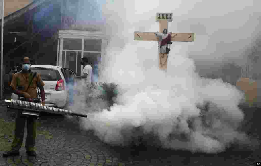 An health worker fumigates an area to control the breeding of mosquitoes in Mumbai, India.