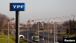 FILE - A sign of state-run energy company YPF is seen alongside a road in Buenos Aires, Aug. 28, 2014.