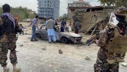 Afghan men take pictures of a vehicle from which rockets were fired, as Taliban forces stand guard, in Kabul, Afghanistan August 30, 2021. (REUTER/Stringer)