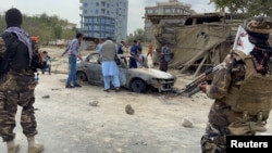 阿富汗人在喀布爾拍攝一輛發射了火箭彈的車輛的照片，塔利班武裝人員守在一旁。(2021年8月30日)