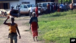 Ivorian refugees walk in the village of Loguatuo in Liberia (file photo - 10 Dec 2010)