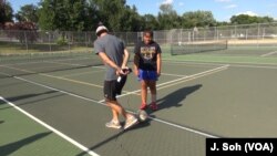 Coach Johnson instructs tenth grader Hayblute Paw, who has built on her knowledge of her fellow players to improve her skills in scrimmages.