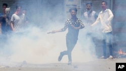 A Kashmiri Muslim protester throws back a teargas shell at Indian paramilitary soldiers in Srinagar, Indian-controlled Kashmir, July 10, 2016. 