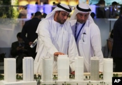 Men look at an architectural model of a housing development at the Cityscape Global exhibition, in Dubai, United Arab Emirates, Sept. 11, 2017.