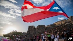 Demonstrators march against governor Ricardo Rosello, in San Juan, Puerto Rico, Wednesday, July 17, 2019. (AP Photo/Dennis M. Rivera Pichardo)