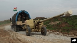 Iraqi Kurdish forces tow a howitzer near the front lines on their way to the city of Sinjar, Iraq, Dec. 19, 2014.
