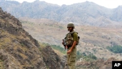 FILE - A Pakistan army soldier stands guard in the Pakistani tribal area of Khyber near the Torkham border post between Pakistan and Afghanistan.