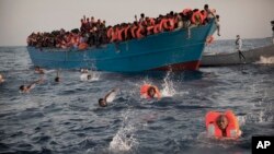 Des migrants sautent à l'eau d'un bateau surpeuplé en bois pendant qu’ils ils sont secourus par des membres d'une ONG Proactiva Open Arms lors d'une opération de sauvetage en Méditerranée, à environ 21 km au nord de Sabratha, la ville libyenne en 2016. (AP Photo / Emilio Morenatti)