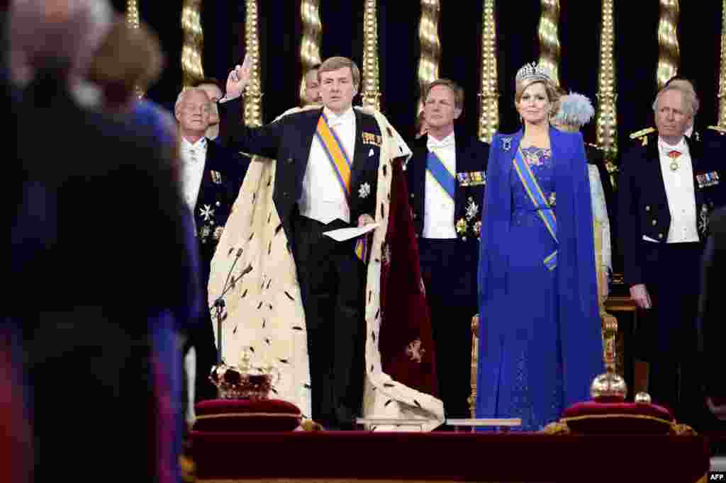 Dutch King Willem-Alexander raises his hand to take the oath by Queen Maxima and members of the royal household at his investiture in Nieuwe Kerk (New Church) in Amsterdam, the Netherlands.