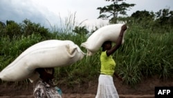 Des femmes congolaises portent des sacs de nourriture sur leurs têtes lors d'une distribution de nourriture à Kasala, dans la région agitée du Kasaï, RDC, 25 octobre 2017.