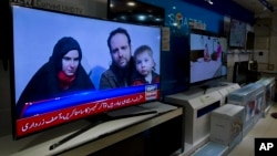 A Pakistani channel broadcasts a report about western couple, seen at a local electronic shop in Islamabad, Pakistan, Thursday, Oct. 12, 2017.