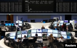 Traders sit at their desks in front of the DAX board at the Frankfurt stock exchange, Germany, June 29, 2015.