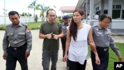 FILE - Singaporean journalist Lau Hon Meng, center left, and Malaysian journalist Mok Choy Lin, both accused of flying drones illegally over parliament buildings, are escorted during their trial at a court in Naypyitaw, Myanmar, Nov. 10, 2017.