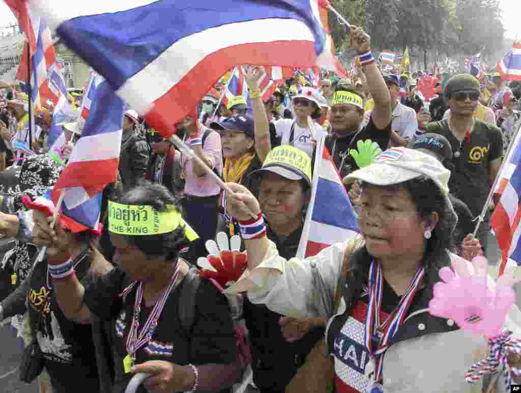 Anti-government protesters wave flags as they march on the street during a warm-up rally to paralyze the capital Tuesday, Jan. 7, 2014 in Bangkok, Thailand.