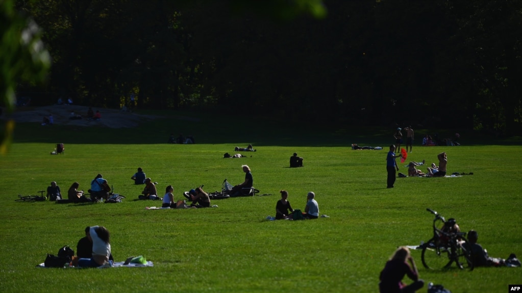 People sit in the grass at Central Park on October 15, 2020 in New York City. (Photo by Angela Weiss / AFP)