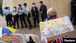 Seorang pendukung pro-demokrasi memegang poster yang menyerukan pembebasan semua tahanan politik, karena delapan dari 12 aktivis Hong Kong ditahan di China daratan tahun lalu. (Foto: Reuters)