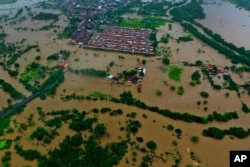 Air banjir menggenangi kota Itapetinga di wilayah selatan negara bagian Bahia, Brasil, Minggu 26 Desember 2021. (Foto: AP)
