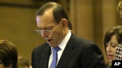 Perdana Menteri Australia Tony Abbott menyanyikan himne dalam misa di St. Mary's Cathedral mengenang korban Malaysia Airlines MH17.