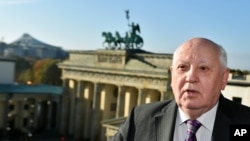 Former Soviet Leader Mikhail Gorbachev stands in front of the Brandenburg Gate in Berlin, Germany, Nov. 8, 2014. 