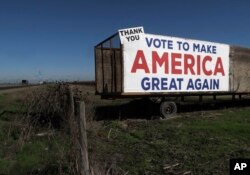 A Trump campaign sign is displayed near Los Banos, California, Dec. 16, 2016. A local farmer says Donald Trump's campaign vow to deport immigrants who are in the country illegally pushed him to buy more equipment, cutting the number of workers he’ll need.