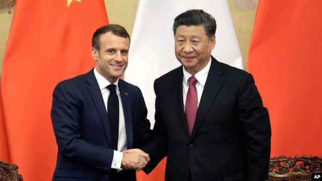 2019年11月6日,中国国家主席习近平和法国总统马克龙在人民大会堂举行联合记者会后握手.
