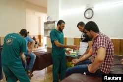 Medics help men donating blood during a campaign to supply blood to a hospital in the rebel-held town of Dael, in Deraa Governorate, Syria May 1, 2016.