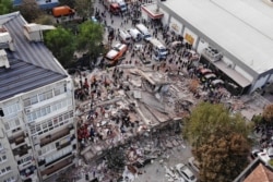 Gambar dari drone menunjukkan orang-orang melakukan pencarian korban di sebuah bangunan yang runtuh setelah gempa bumi yang kuat melanda Laut Aegea yang meruntuhkan sejumlah bangunan di provinsi pesisir Izmir, Turki, 30 Oktober 2020.