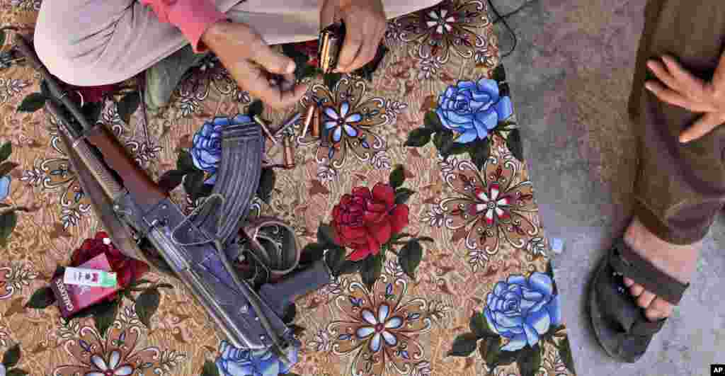 A Syrian rebel fighter prepares his AK-47 before going on patrol in Marea, on the outskirts of Aleppo, Syria, September 4, 2012. 