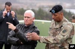 U.S. Vice President Mike Pence, left, is briefed by U.S. Gen. Vincent Brooks, right, commander of the United Nations Command, U.S. Forces Korea and Combined Forces Command from Observation Post Ouellette in the Demilitarized Zone (DMZ), near the border village of Panmunjom, South Korea, April 17, 2017.