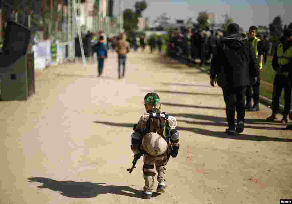 A Palestinian boy wearing a military costume arrives at a military-style graduation ceremony for youths who were trained at one of the Hamas-run Liberation Camps, in Gaza City.