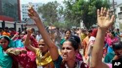 Bangladeshi women workers shout slogans as they participate in a protest outside a garment factory in Dhaka, Bangladesh, Monday, June 17, 2013. The workers protested demanding outstanding salary payments. (AP Photo/A.M. Ahad)