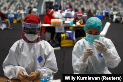 Petugas kesehatan menyiapkan vaksin Sinovac untuk COVID-19 saat vaksinasi massal untuk tenaga medis Indonesia, di Stadion Istora Senayan, Jakarta, 4 Februari 2021. (Foto: REUTERS/Willy Kurniawan)