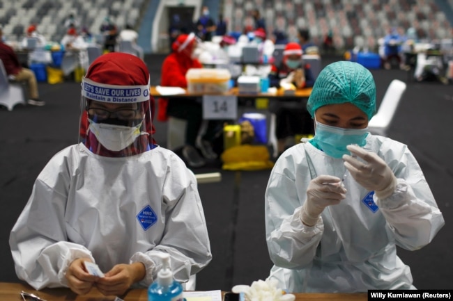 Petugas kesehatan menyiapkan vaksin Sinovac untuk COVID-19 saat vaksinasi massal untuk tenaga medis Indonesia, di Stadion Istora Senayan, Jakarta, 4 Februari 2021. (Foto: REUTERS/Willy Kurniawan)