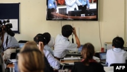 FILE - Cambodian and foreign journalists watch a live-feed video in a press room at the Extraordinary Chamber in the Courts of Cambodia, in Phnom Penh, Feb. 3, 2012. 